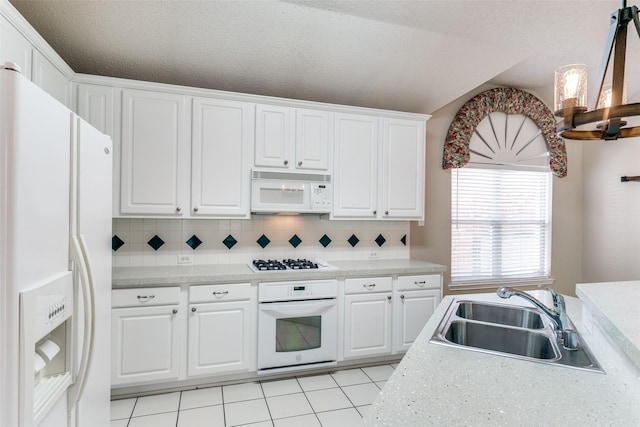 kitchen with white appliances, a sink, light countertops, white cabinets, and backsplash