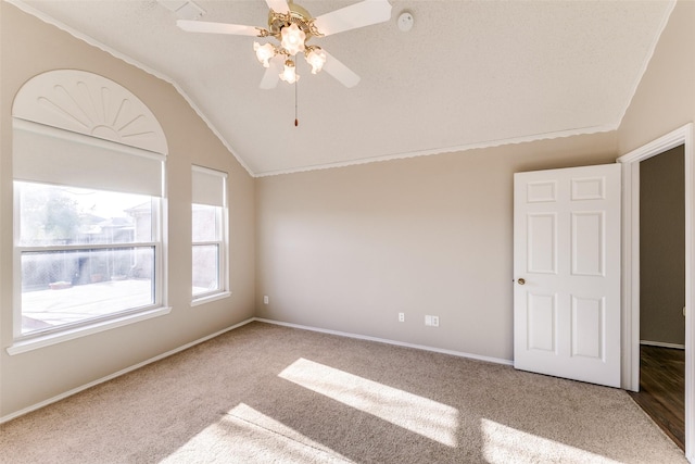 unfurnished room featuring vaulted ceiling, baseboards, carpet floors, and ceiling fan