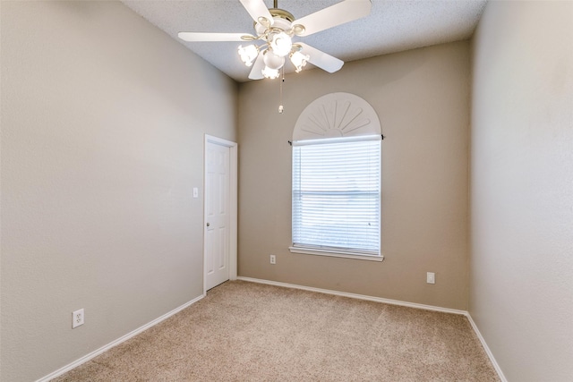 empty room with light colored carpet, a textured ceiling, baseboards, and a ceiling fan