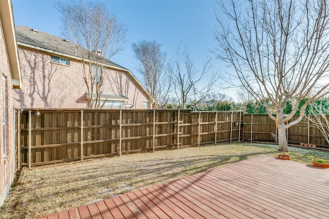 wooden terrace with a fenced backyard and a lawn