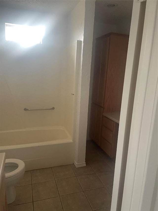 full bath featuring tile patterned flooring, toilet, and washtub / shower combination