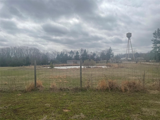 view of yard featuring a rural view and fence