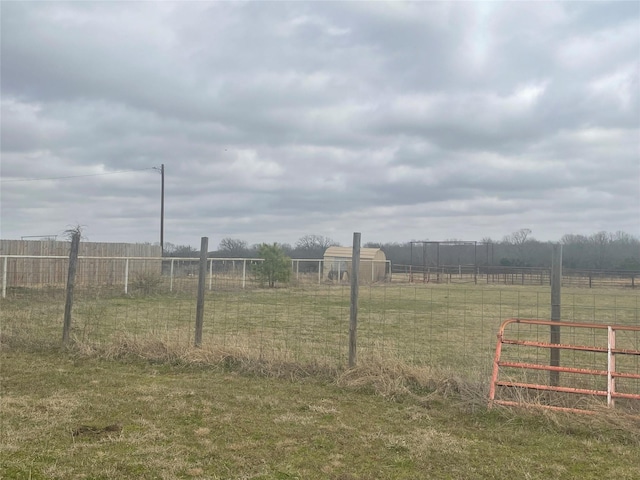 view of yard with a rural view and fence