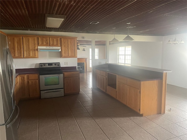 kitchen with stainless steel appliances, wooden ceiling, under cabinet range hood, dark countertops, and tile patterned floors