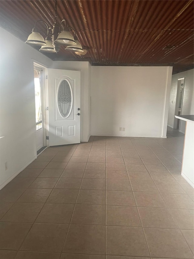 unfurnished room with visible vents, an inviting chandelier, wooden ceiling, and tile patterned flooring