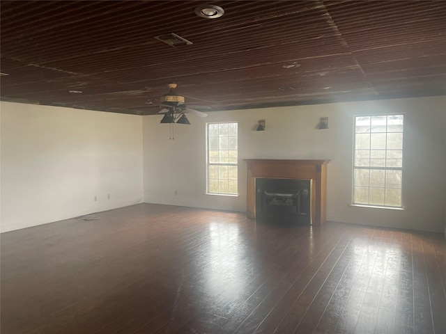 unfurnished living room with visible vents, a fireplace, ceiling fan, and wood-type flooring