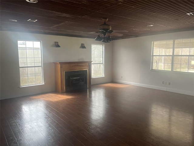 unfurnished living room with dark wood finished floors, wooden ceiling, a fireplace, and a ceiling fan