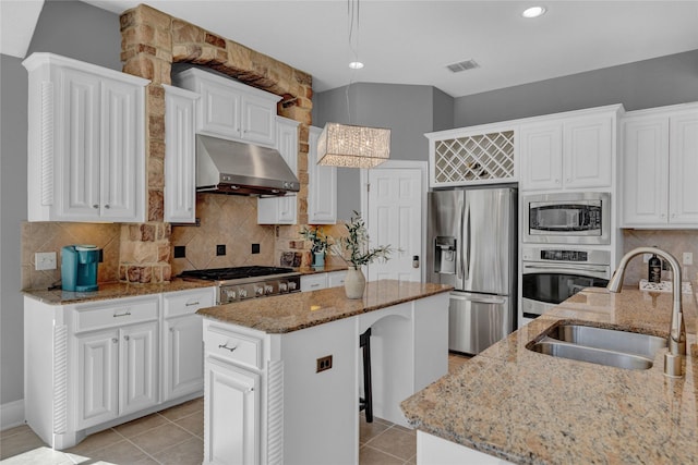 kitchen with visible vents, a sink, stainless steel appliances, under cabinet range hood, and a center island