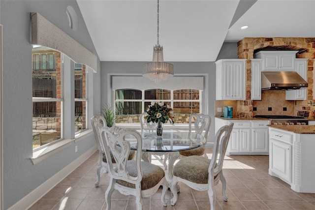 dining room featuring an inviting chandelier, light tile patterned flooring, baseboards, and lofted ceiling