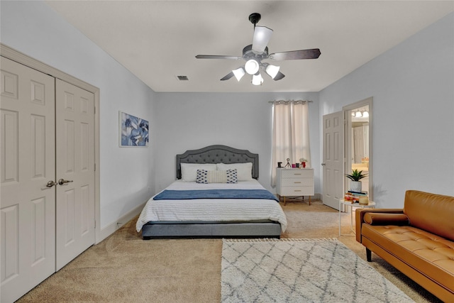 carpeted bedroom with a closet, visible vents, baseboards, and a ceiling fan