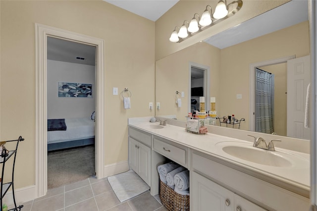 ensuite bathroom with tile patterned floors, double vanity, ensuite bathroom, and a sink