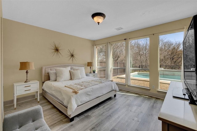 bedroom featuring light wood-type flooring, baseboards, and visible vents