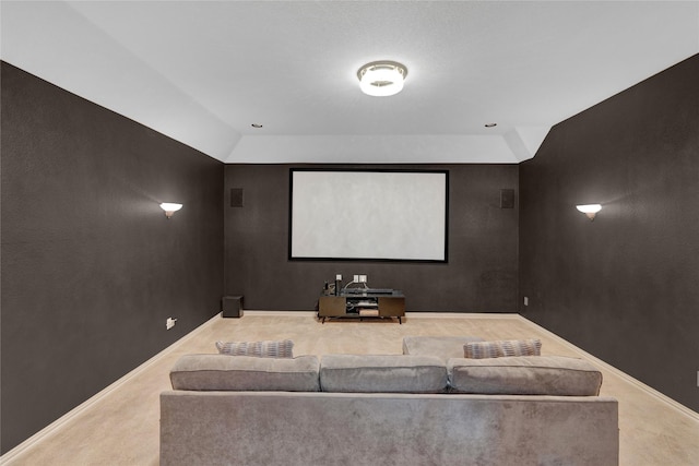 carpeted cinema featuring vaulted ceiling and baseboards