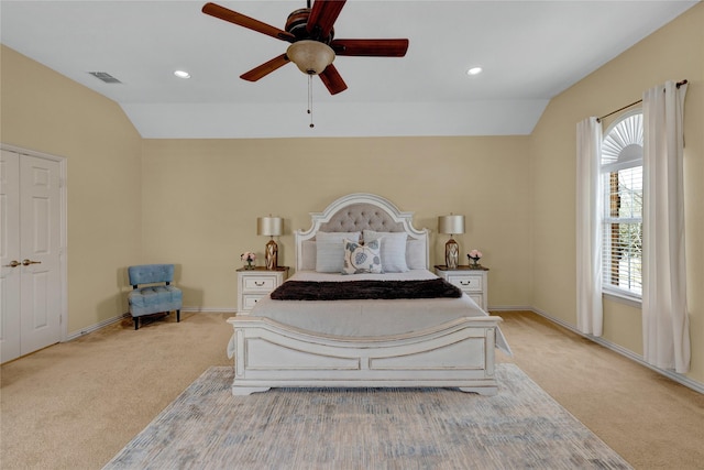 bedroom featuring visible vents, light colored carpet, baseboards, and vaulted ceiling