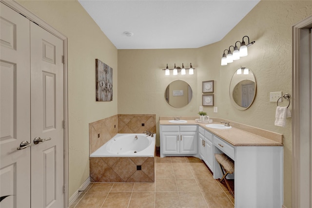 full bathroom featuring a sink, a jetted tub, double vanity, and tile patterned flooring