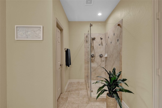 bathroom featuring tile patterned floors, visible vents, baseboards, and a shower stall