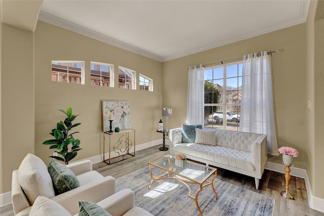 living area with baseboards, wood finished floors, and crown molding