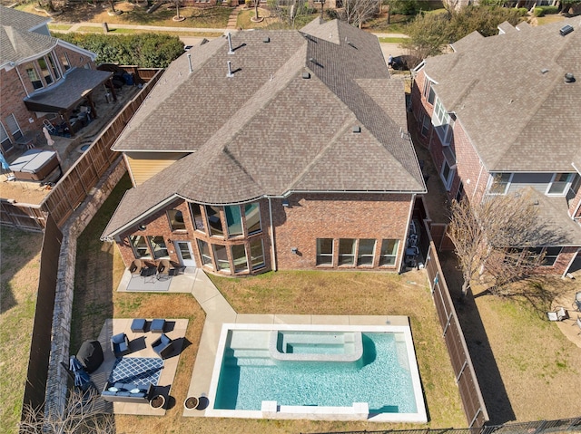 exterior space featuring a lawn, a patio, a hot tub, and a fenced backyard