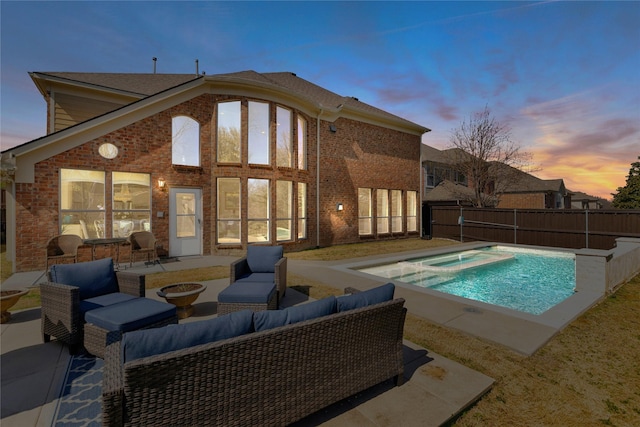 pool at dusk with a fenced in pool, fence, outdoor lounge area, an in ground hot tub, and a patio