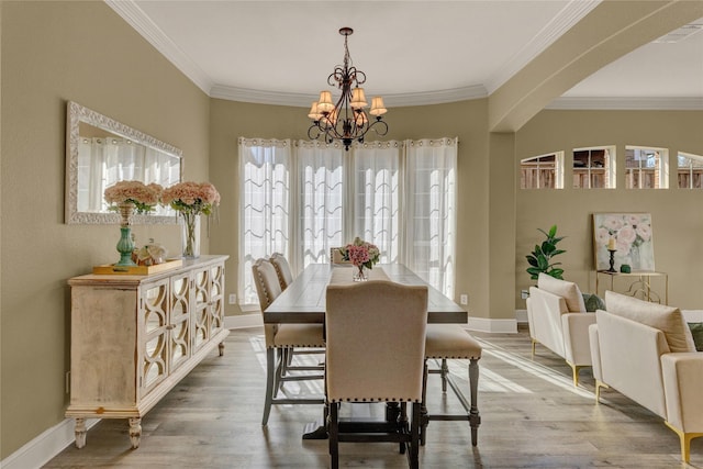 dining space featuring ornamental molding, baseboards, an inviting chandelier, and wood finished floors