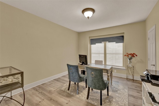 dining space with baseboards and light wood-style floors