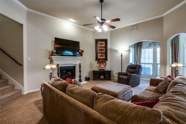 living room featuring visible vents, a fireplace, ornamental molding, stairs, and carpet flooring