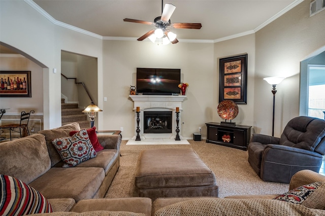 carpeted living room with visible vents, a fireplace with raised hearth, stairway, and crown molding