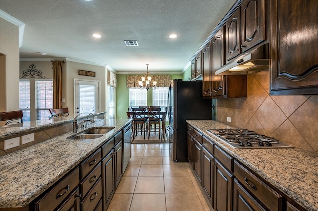 kitchen with visible vents, a sink, appliances with stainless steel finishes, under cabinet range hood, and backsplash