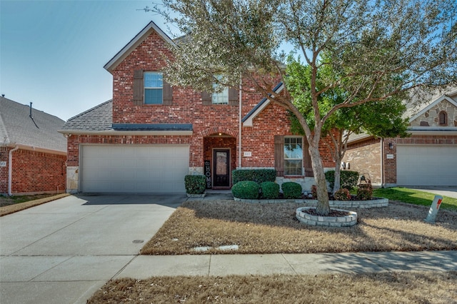 traditional-style house featuring an attached garage, brick siding, driveway, and a shingled roof