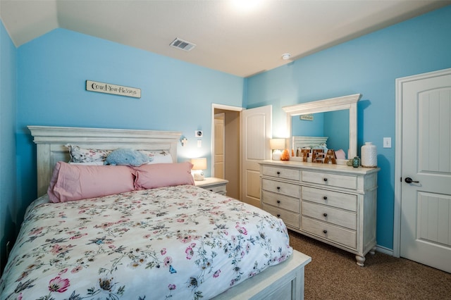 bedroom with lofted ceiling, visible vents, and dark carpet