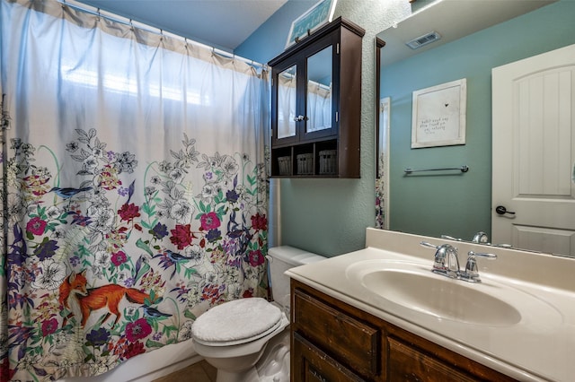 full bath with a shower with shower curtain, toilet, vanity, and a textured wall