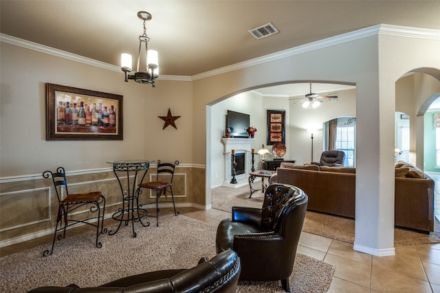 interior space with visible vents, a fireplace with raised hearth, light tile patterned flooring, and crown molding