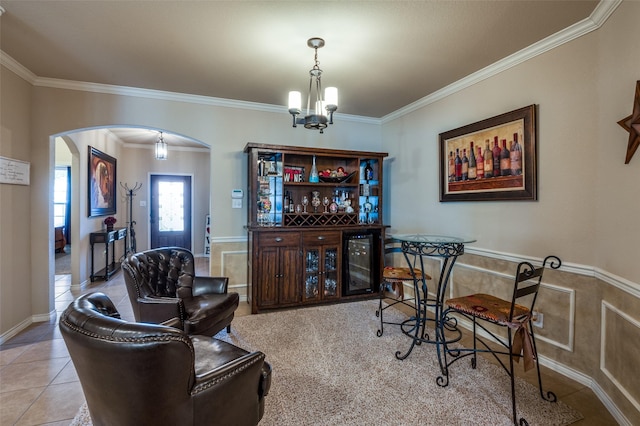 tiled dining room featuring arched walkways, a chandelier, wine cooler, and crown molding