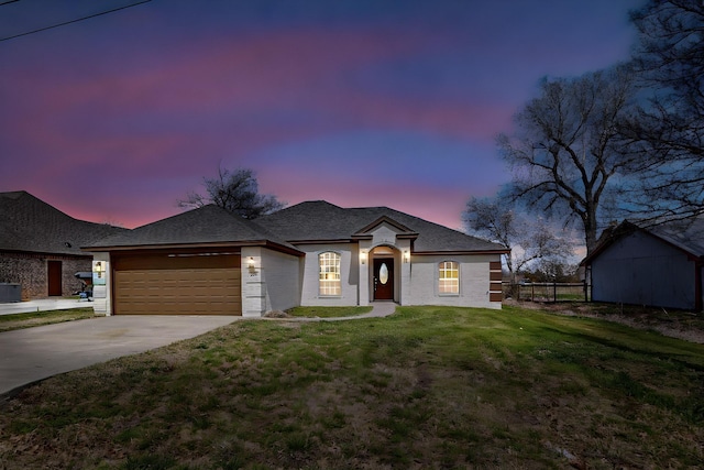 view of front facade featuring fence, a lawn, a garage, and driveway