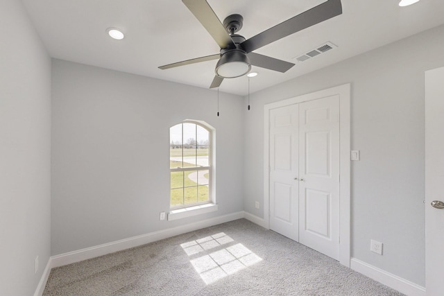 unfurnished bedroom featuring visible vents, baseboards, carpet, and a closet