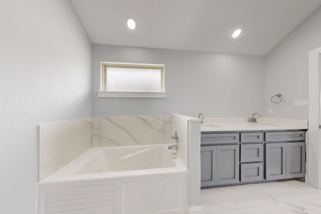 bathroom featuring double vanity, a tub with jets, marble finish floor, and a sink