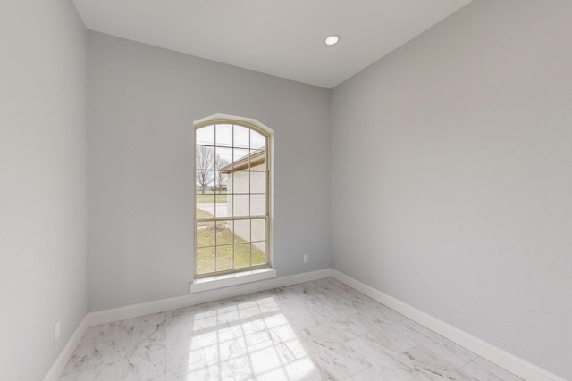 empty room with recessed lighting, marble finish floor, and baseboards