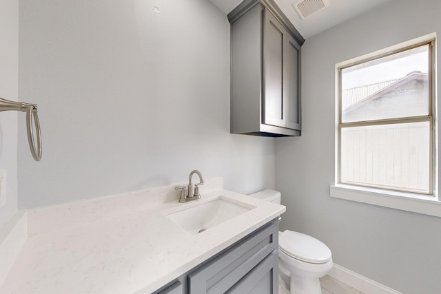 bathroom with visible vents, toilet, vanity, and baseboards