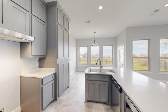 kitchen with visible vents, gray cabinetry, stainless steel dishwasher, and a sink