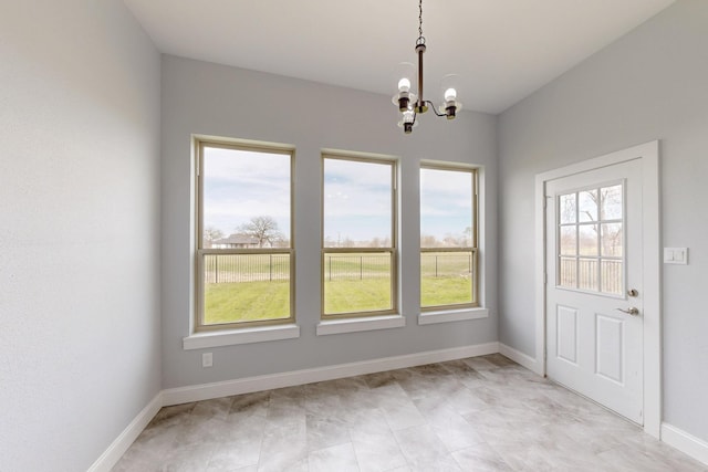 unfurnished dining area with a notable chandelier and baseboards