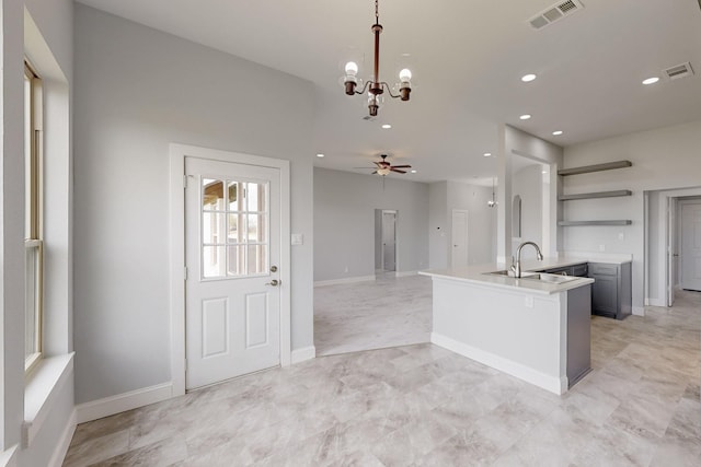 kitchen featuring open shelves, decorative light fixtures, ceiling fan with notable chandelier, and visible vents