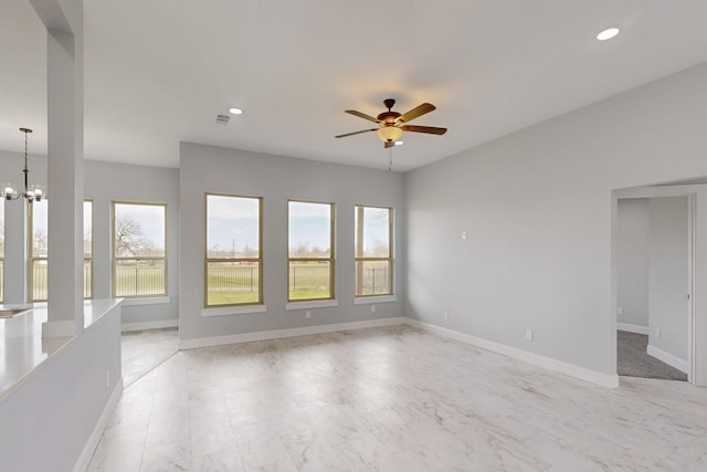 unfurnished room with recessed lighting, ceiling fan with notable chandelier, and baseboards