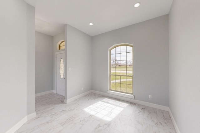 spare room with recessed lighting, marble finish floor, and baseboards