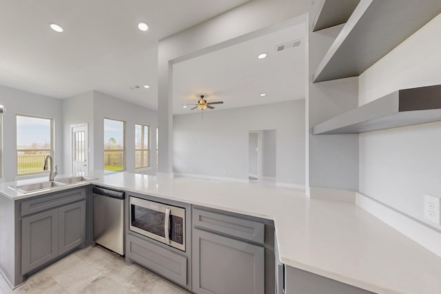 kitchen featuring gray cabinetry, stainless steel appliances, and a sink