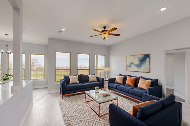 living room with recessed lighting, ceiling fan with notable chandelier, and baseboards