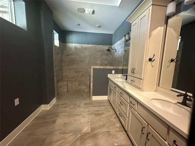 full bathroom with double vanity, baseboards, walk in shower, and a sink