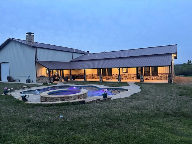 view of pool with a lawn, a pool with connected hot tub, and a patio