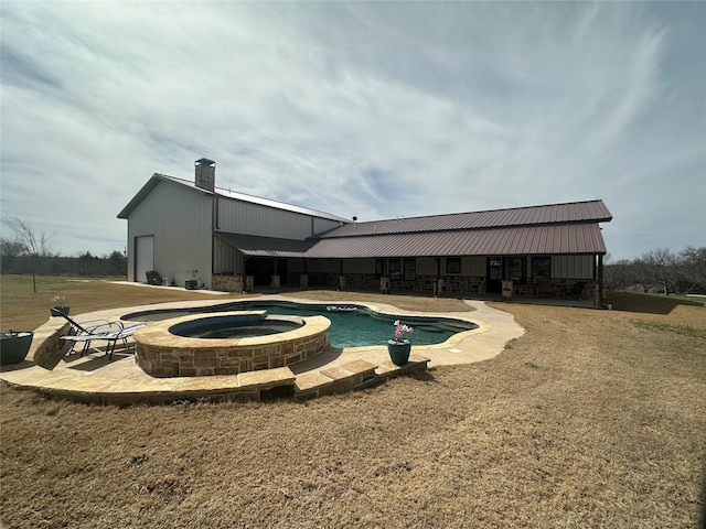 view of swimming pool with a patio and a pool with connected hot tub