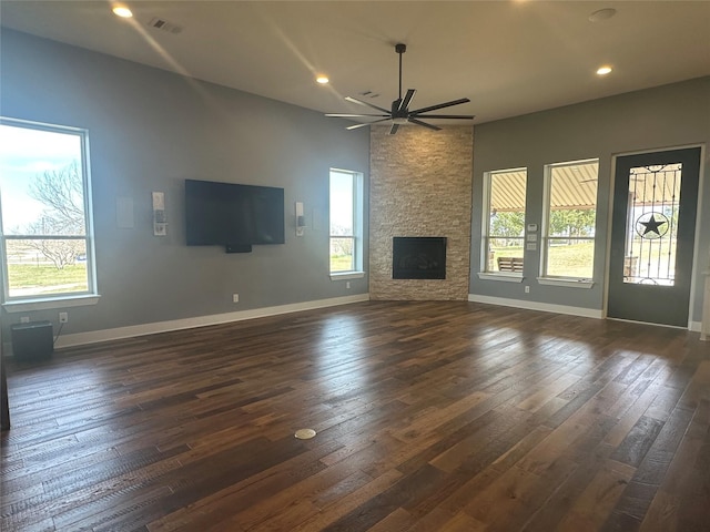 unfurnished living room with ceiling fan, baseboards, dark wood finished floors, and a fireplace