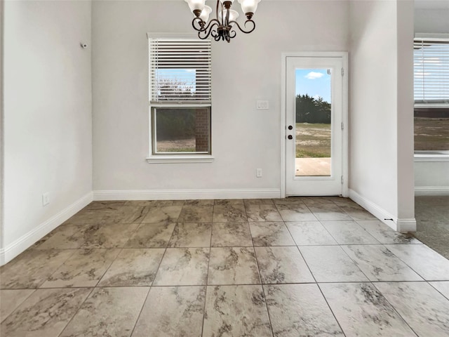 interior space featuring baseboards and a notable chandelier